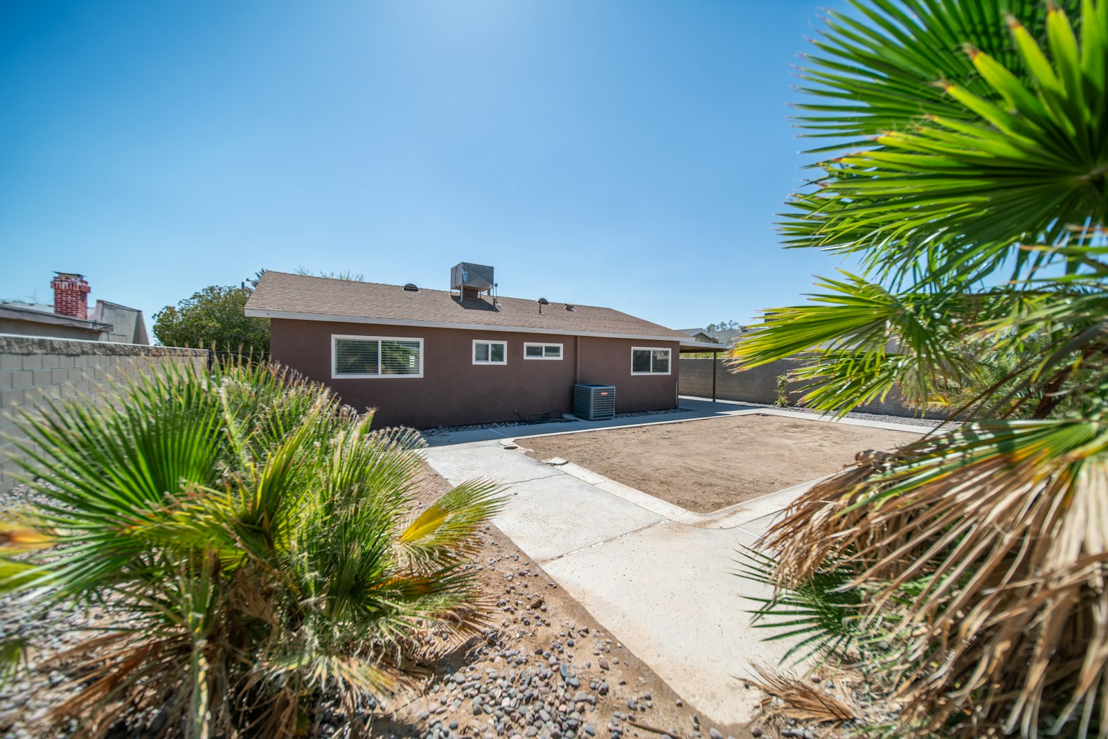 Phoenix-area home with a manicured palm tree and a clean granite front yard.